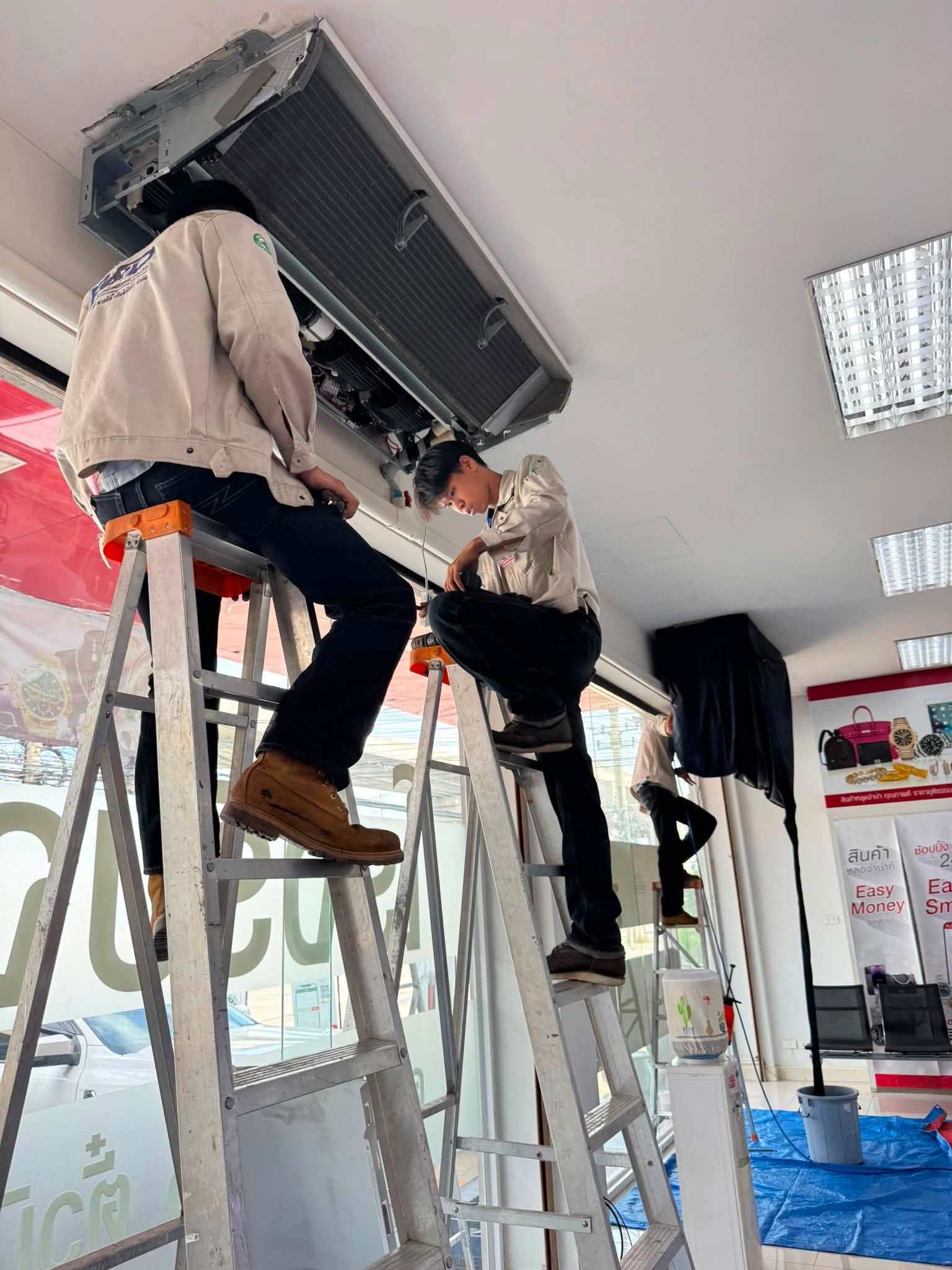 Team removing a ceiling cassette unit for cleaning
