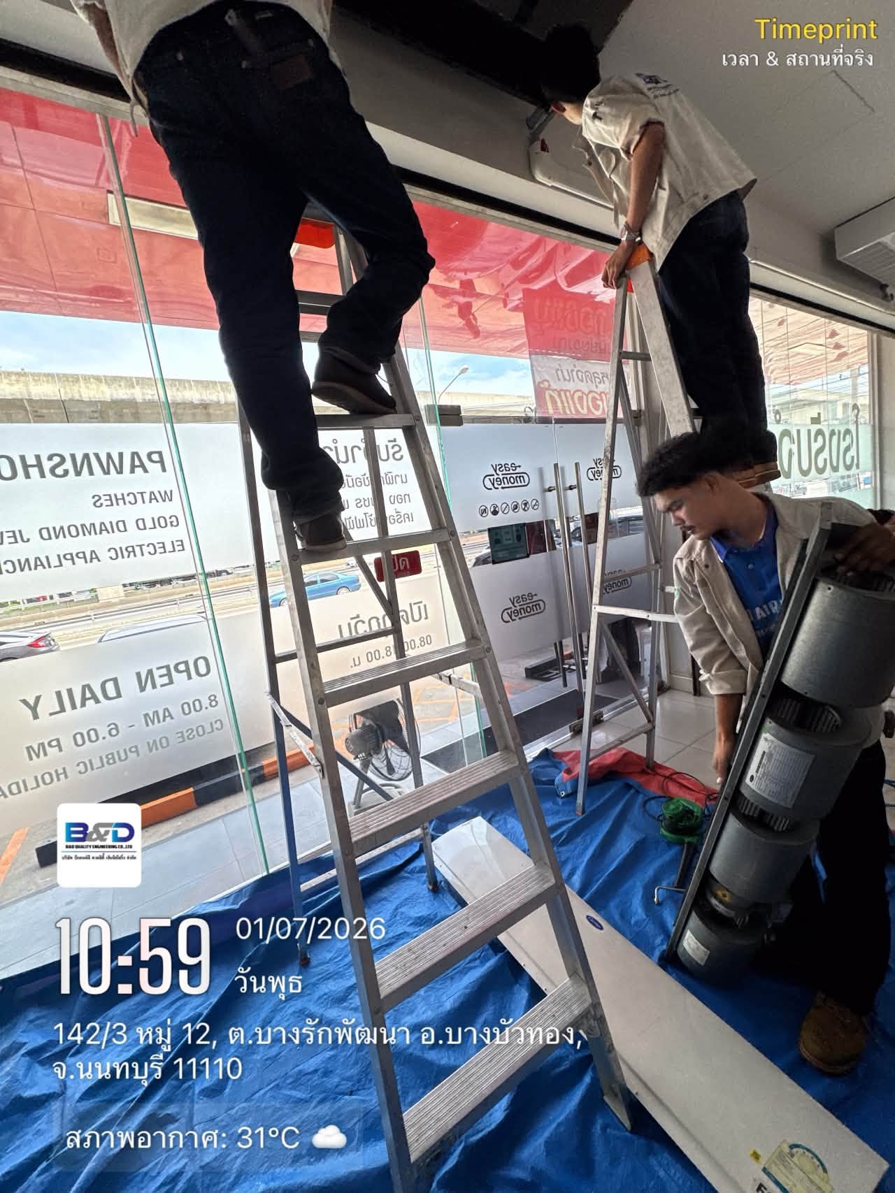 Technician on a ladder servicing a ceiling air conditioner